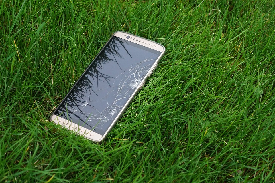 rozbitý mobil v trávě